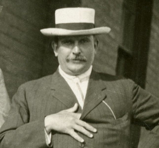 William Butterworth standing outside of a train station depot