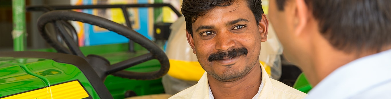 Employee is speaking with a customer at a John Deere dealership located in Pune, Maharashtra, India