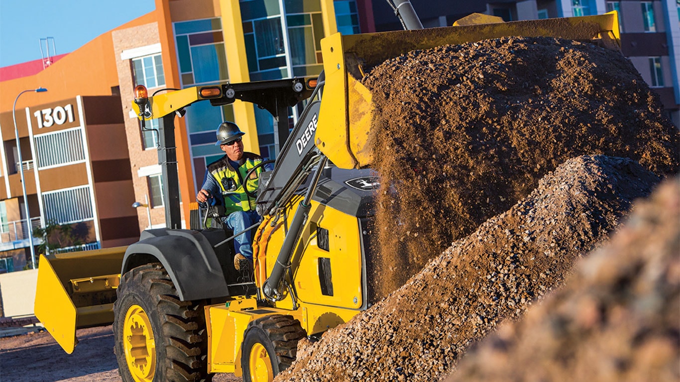 Operator in 210L Tractor Loader looking out the rear of the machine on the jobsite
