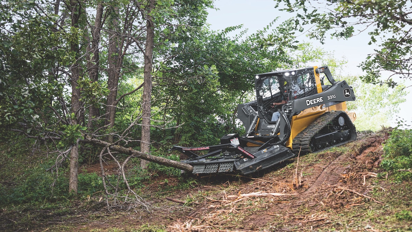 331G with Rotary Cutter attached on a hill cutting down a tree