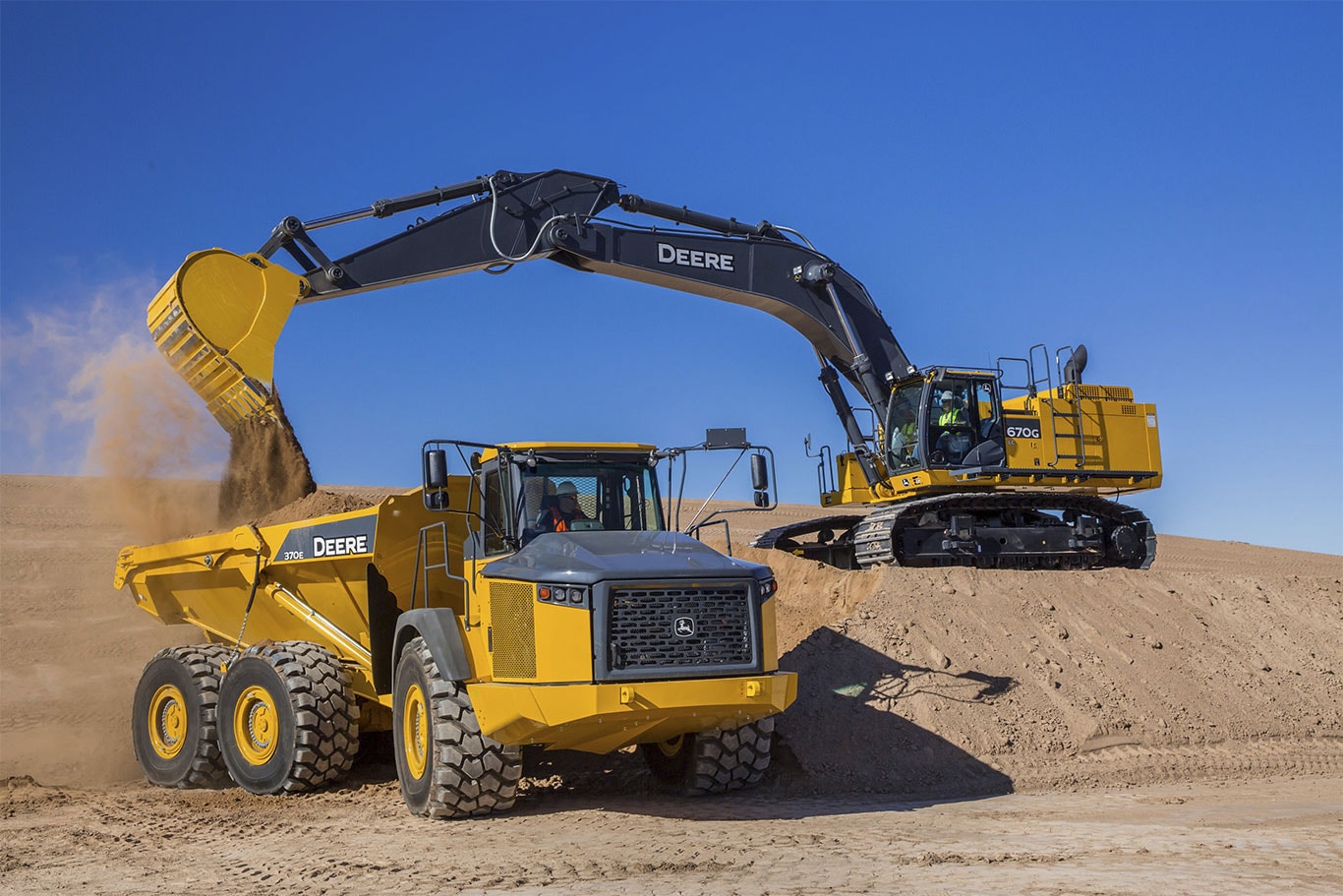 670G LC excavator dumbs a load of dirt into an articulated dump truck