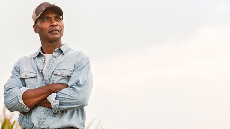 Man with his arms crossed staring into the distance