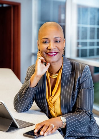 Portrait of Felecia Prior with her work laptop and phone in-hand