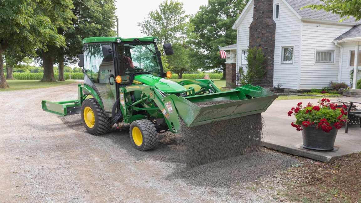 4-in-1 bucket dumping gravel on driveway.