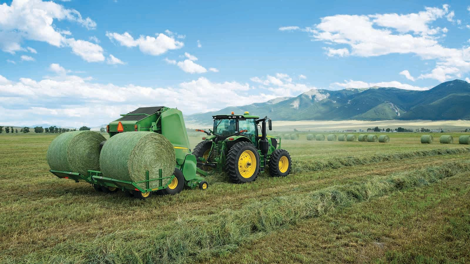 A John Deere 560M Round Baler equipped with a new A520R Plus2 Accumulator carries up to