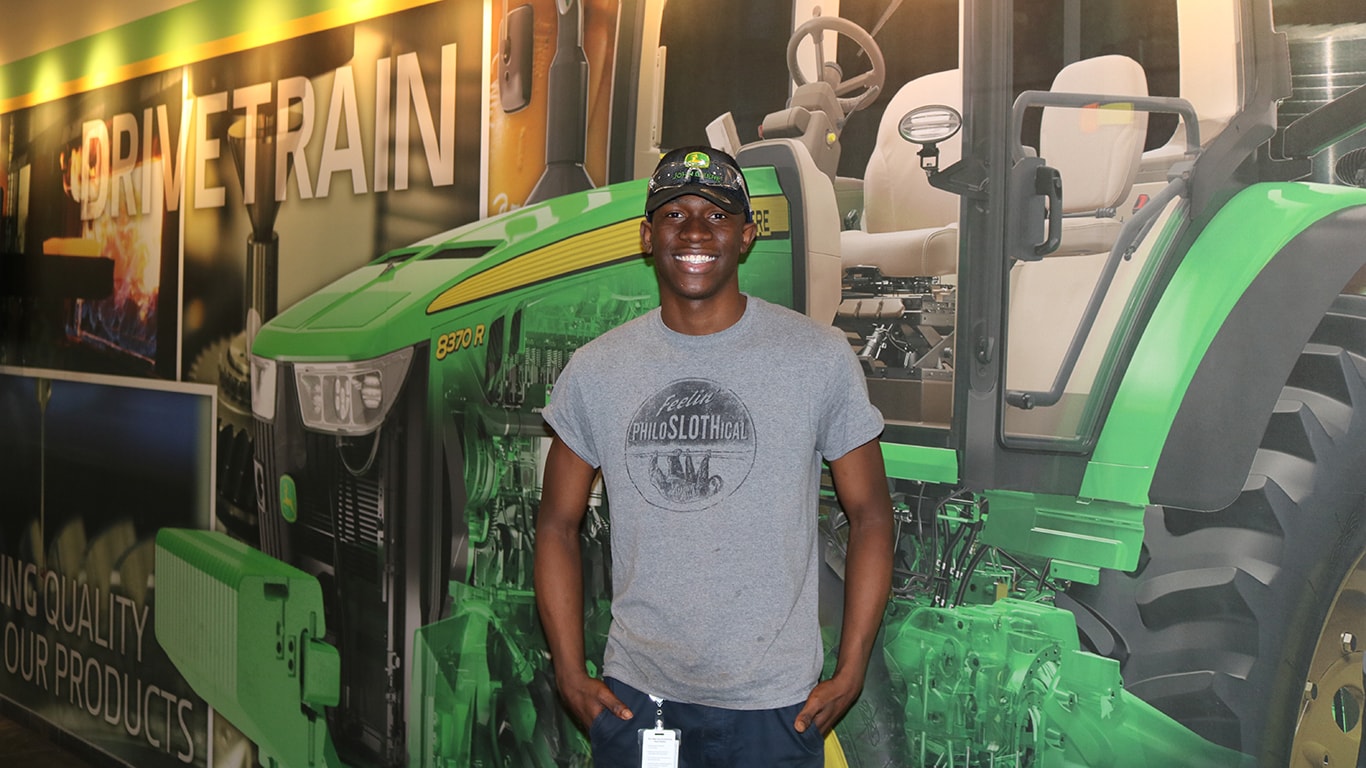 Man in front of John Deere mural