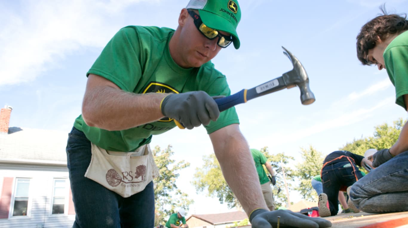 John Deere employee hammering nails during a Habitat for Humanity project