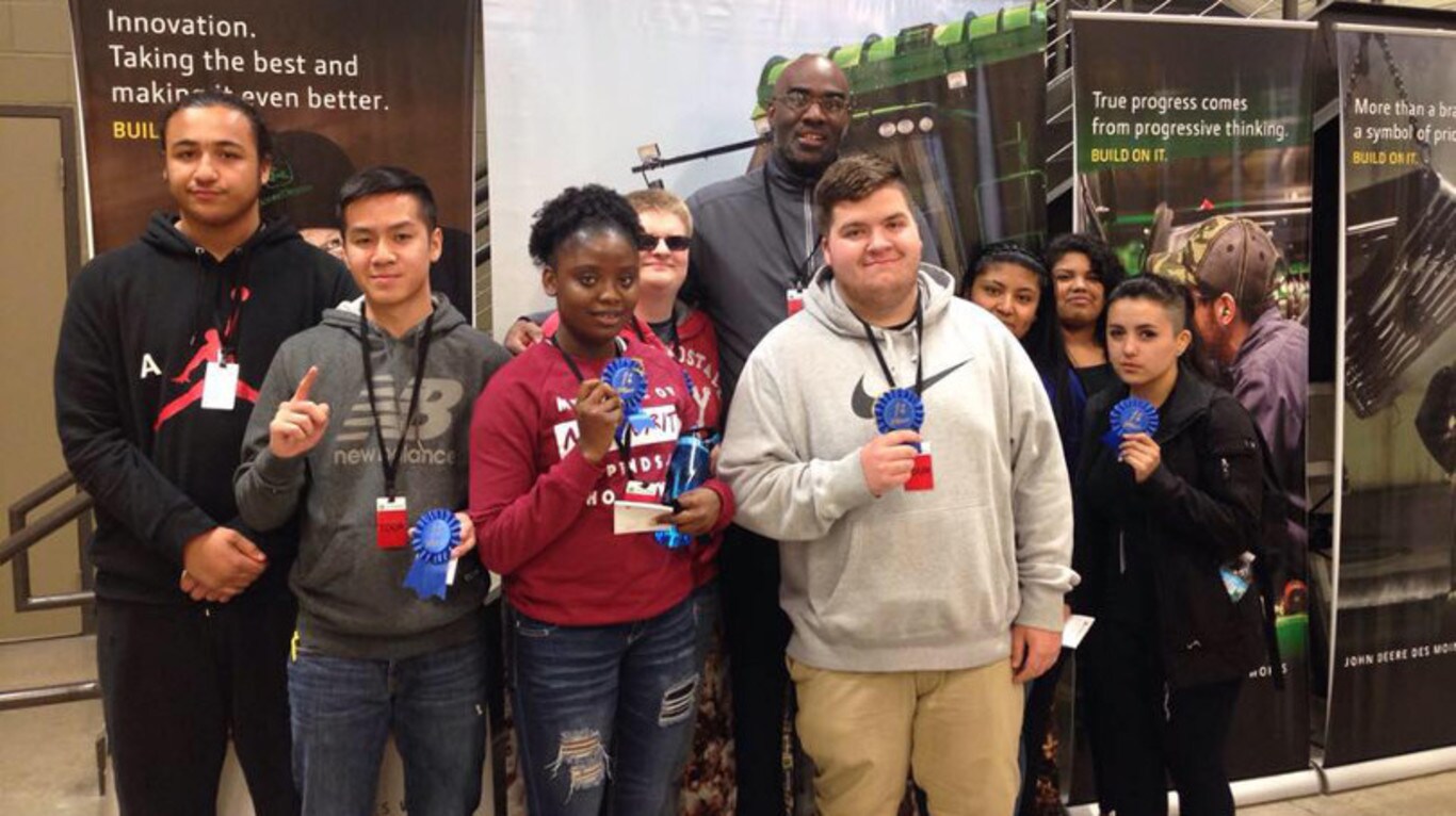 iJAG students pose with their awards in front of the John Deere display at the Career Development Conference.