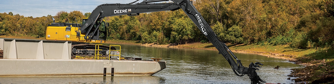 A John Deere excavator works on a barge to clean up the waters