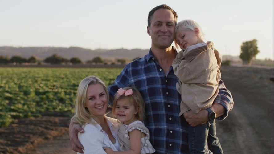 A family of four standing in front of a farm road