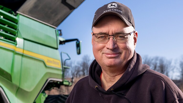 Glenn Pope standing in front of a combine