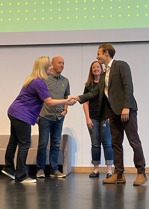 Three judges line up to shake the winner's hand