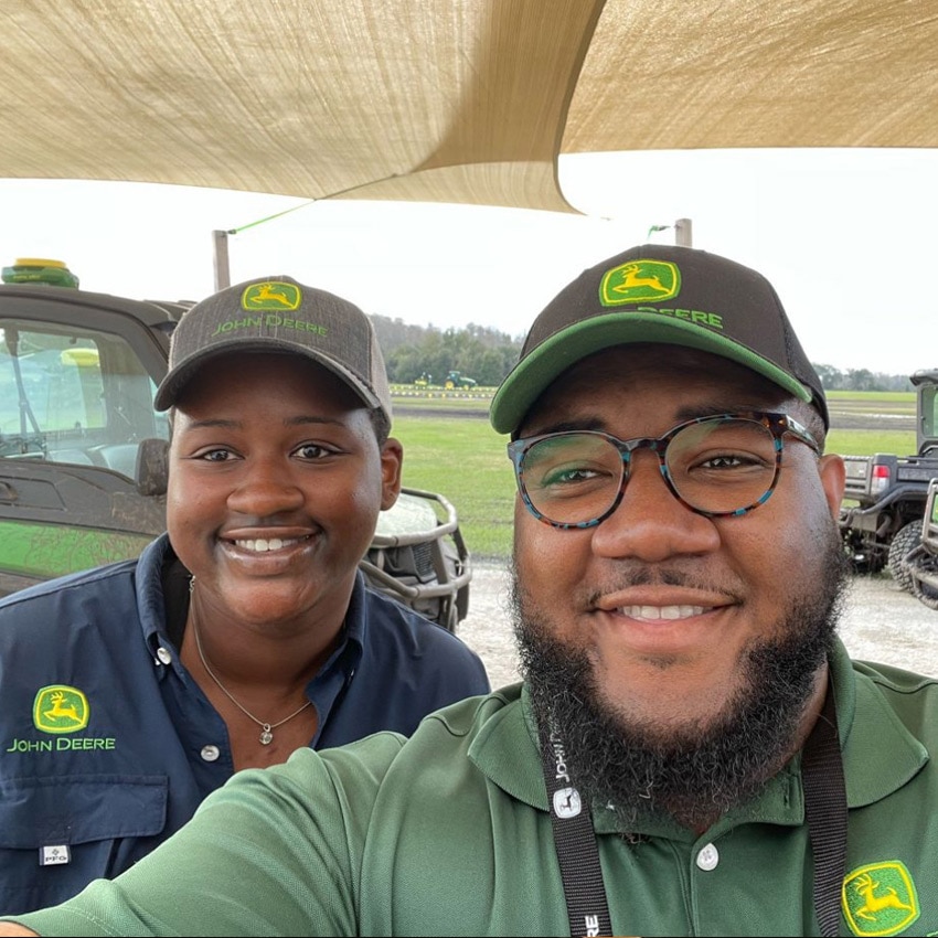 Jericho takes a selfie with a colleague, both wearing John Deere uniforms