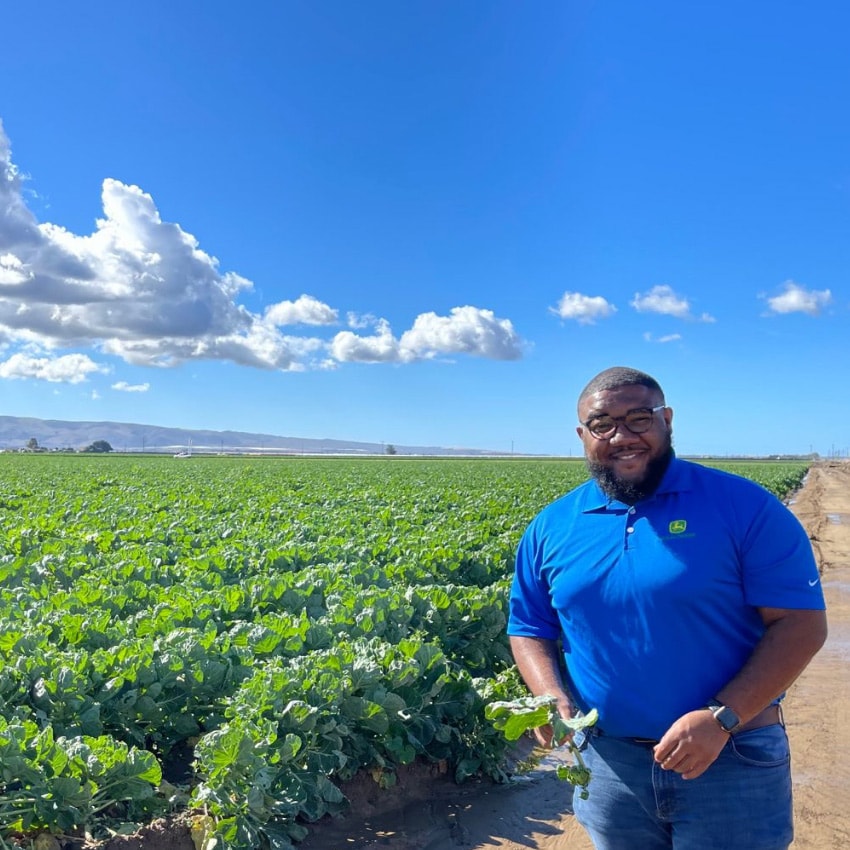 Jericho poses for a photo with bountiful fields of crops in the background