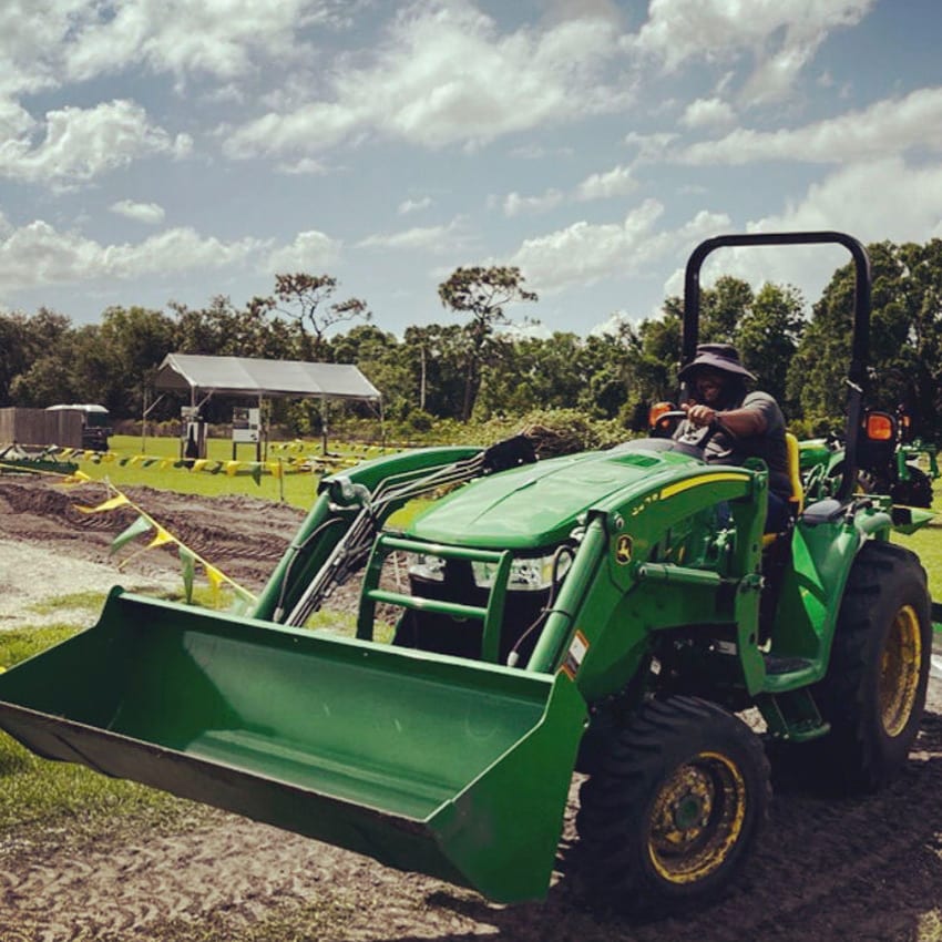 Jericho drives a John Deere tractor with a scoop attachment