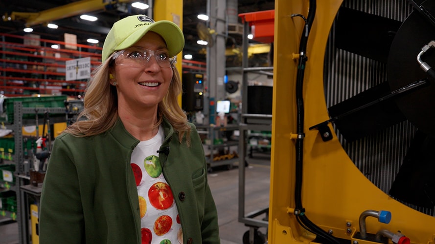 Kat Roberts tours a John Deere factory facility with a big smile.