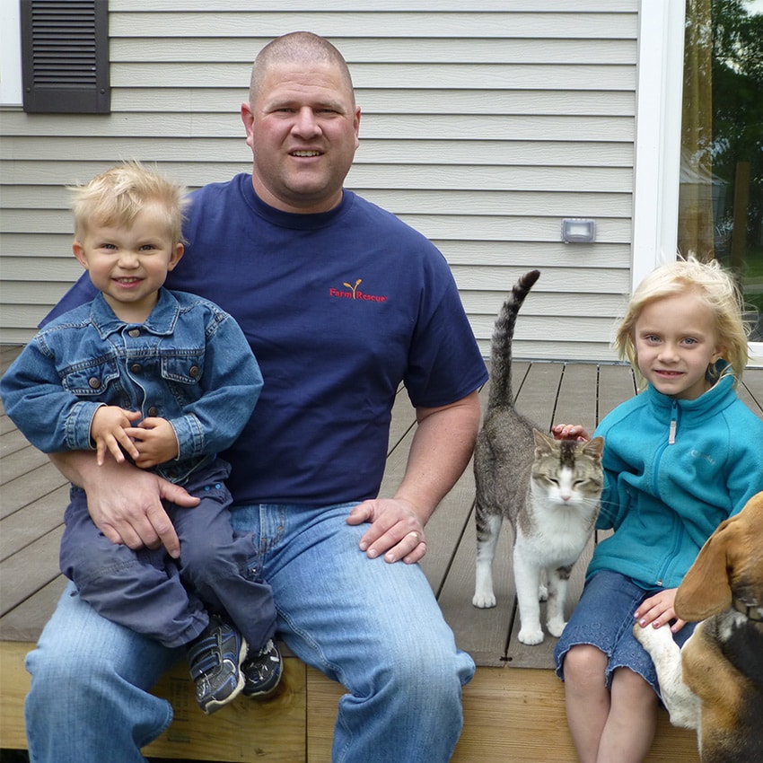 Matt Klemetson sits on his front porch with his three kids, cat, and dog. 