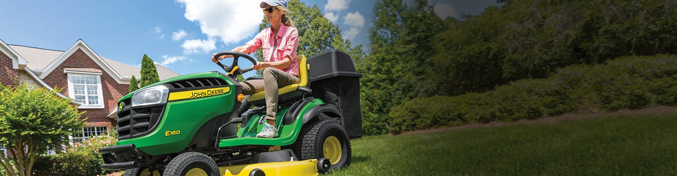 Woman driving an e160 mower in her yard