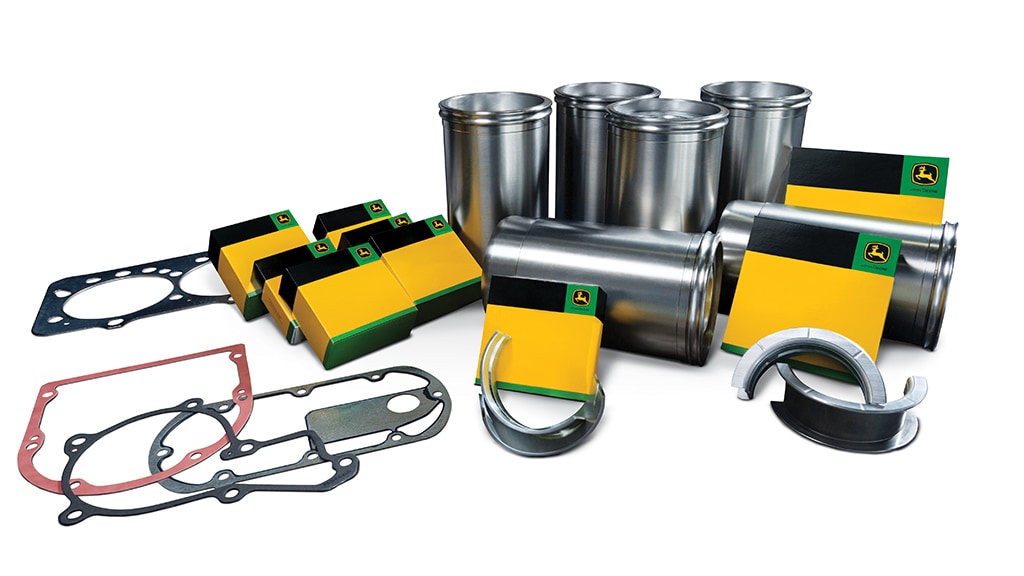 Engine overhaul kit with metal sleeves, gaskets, and yellow-green branded boxes.