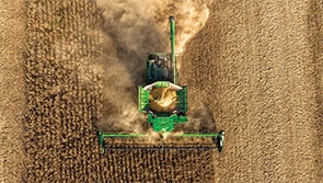 Aerial shot of a combine harvester operating in a field.