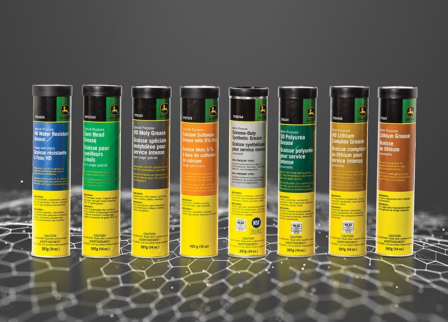 Eight tubes of John&nbsp;Deere greases and lubricants side-by-side on a dark gray background.
