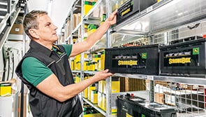 Man handling Strongbox batteries on a steel