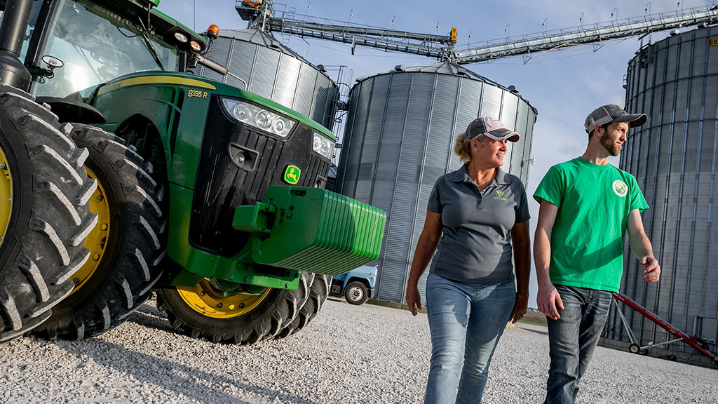 Two people walking away from an 8335 R Tractor in a farm yard