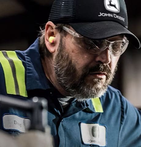 A close-up of a John Deere Reman technician concentrating on their job.