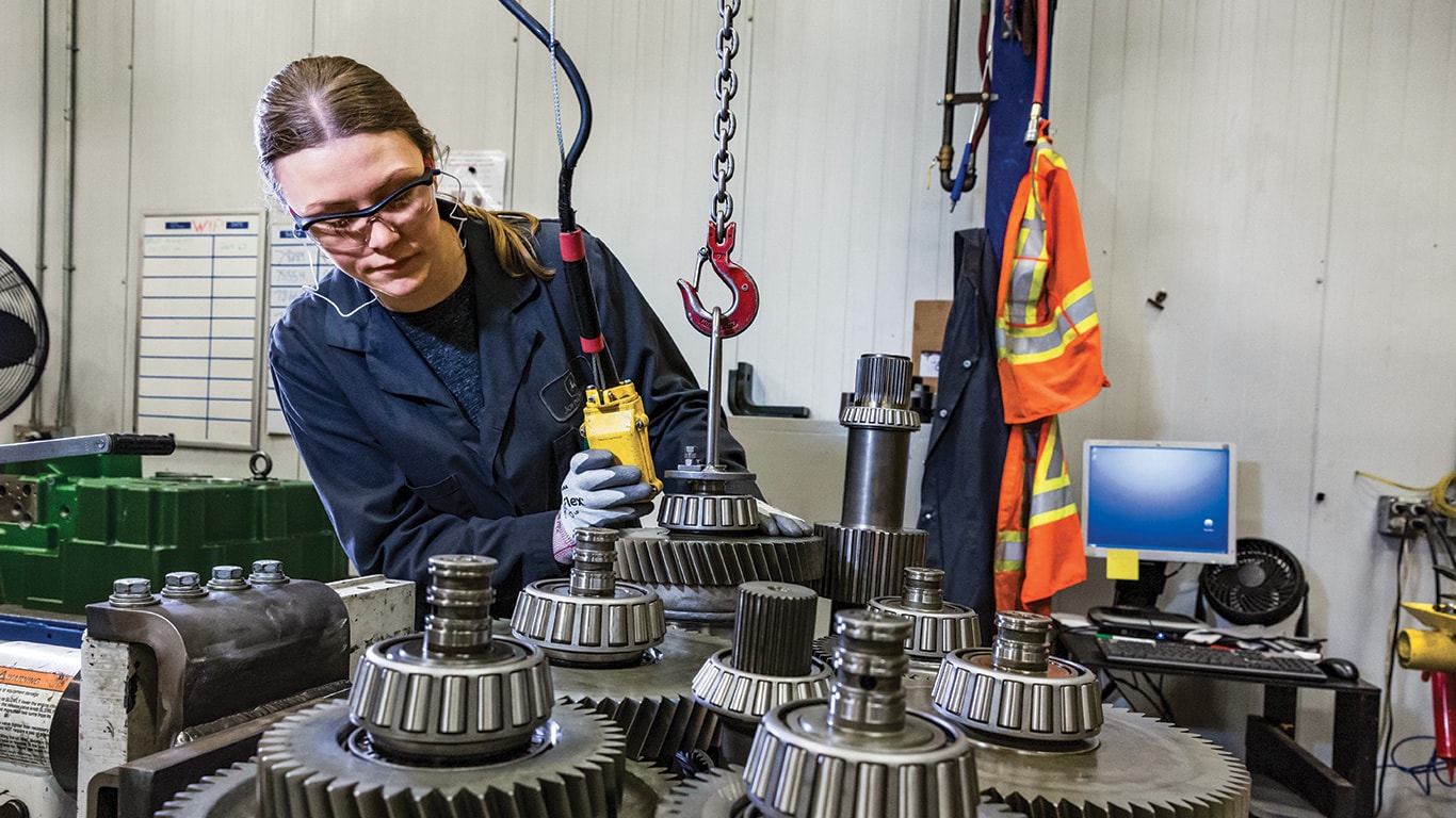 A John Deere Reman technician working on a transmission.