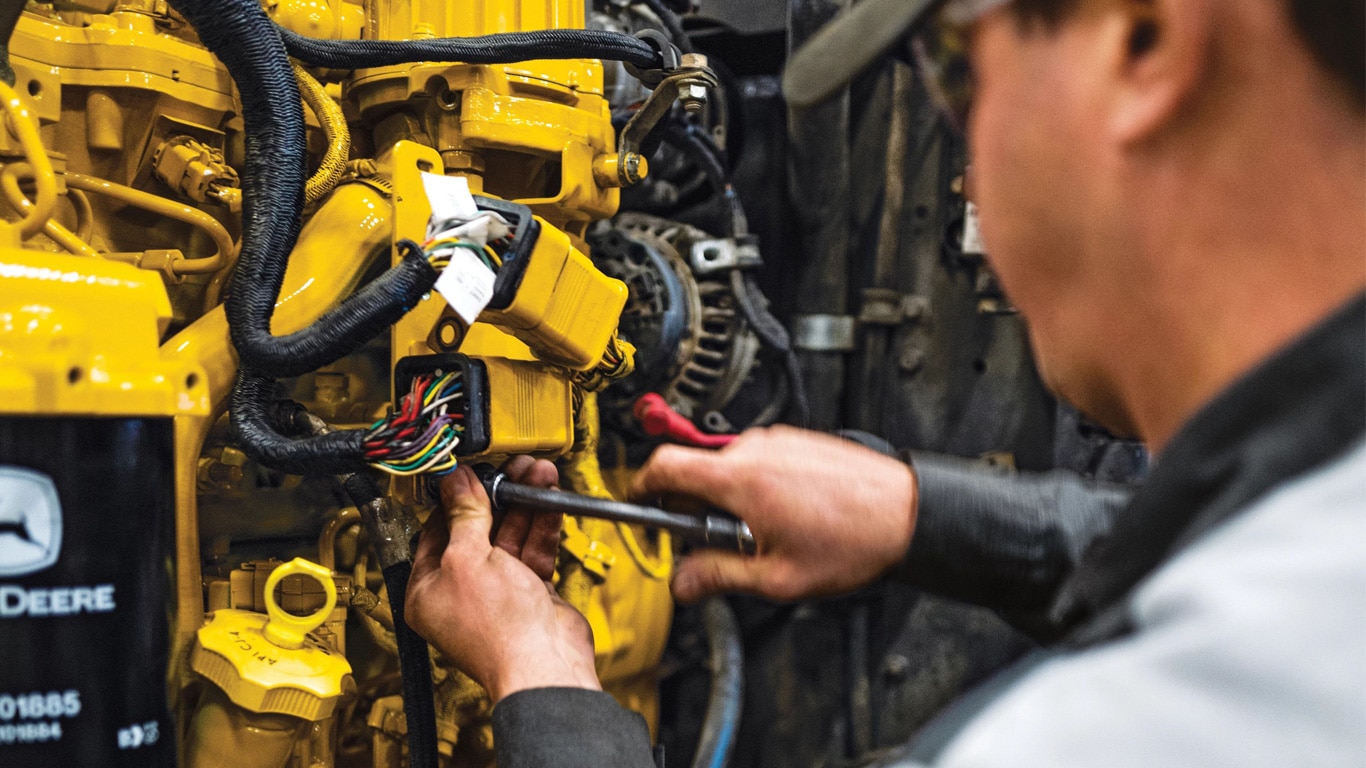 A service technician repairing a wheel loader.