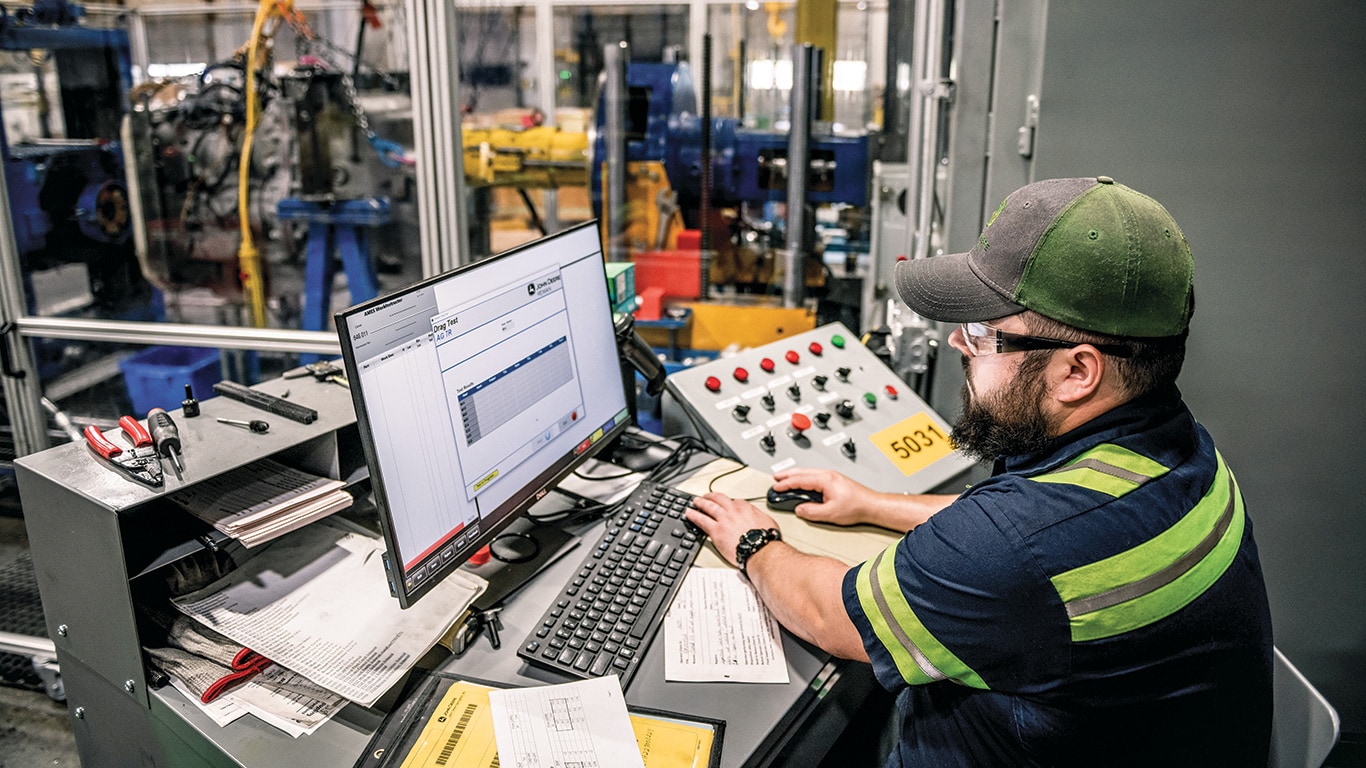 A John Deere Reman technician using a computer to perform a transmission test.