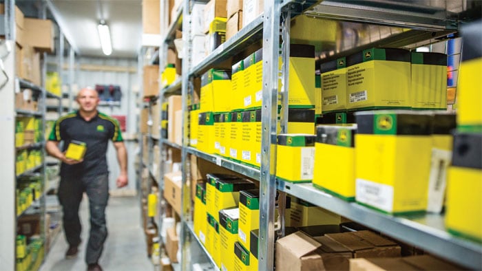 shelf with commercial mowing parts with worker