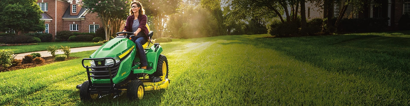 A woman mowing her lawn with an X500 lawn tractor