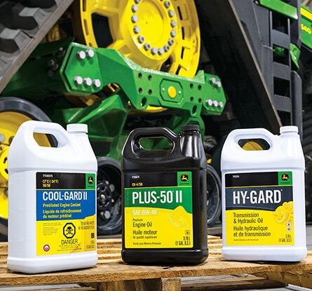 Three fluid containers labeled Cool-Gard II, Plus-50 II, and Hy-Gard on a wooden pallet.