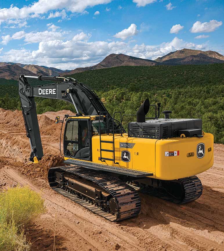 470G LC Excavator digs a trench in front of a mountain range