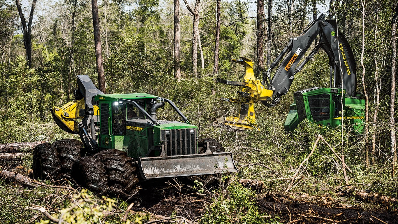 various Deere forestry and logging vehicles in a forest