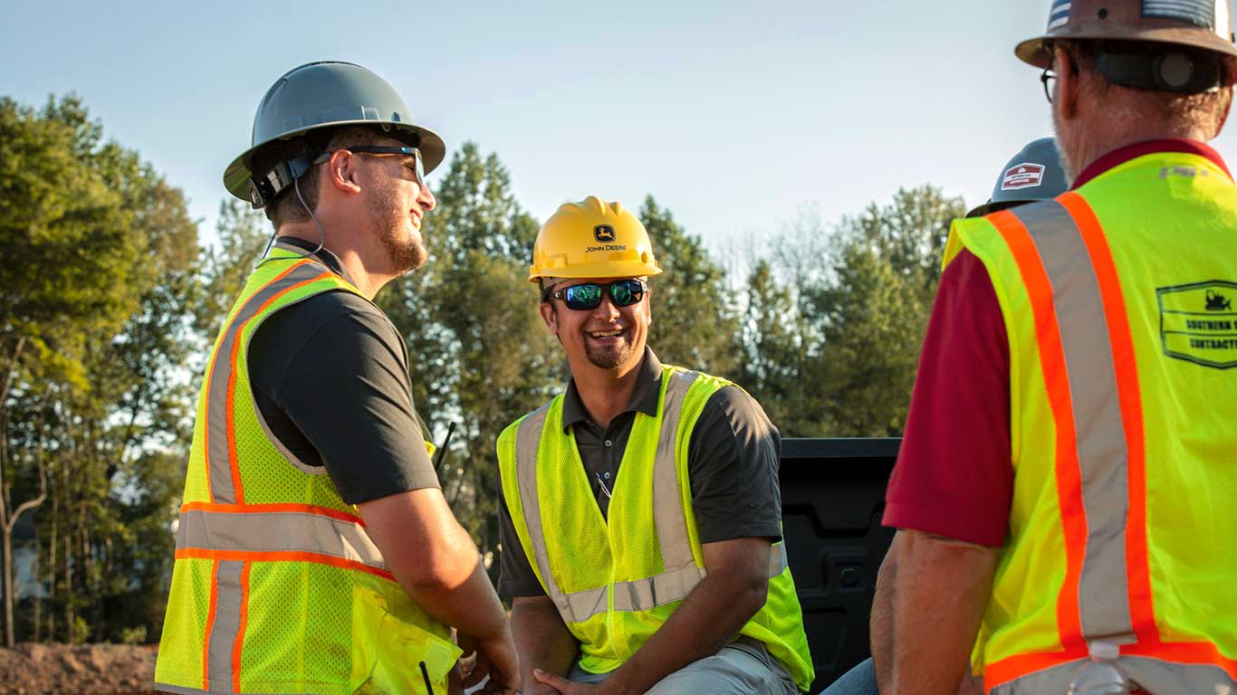 People gather around the back of a service truck talking to each other