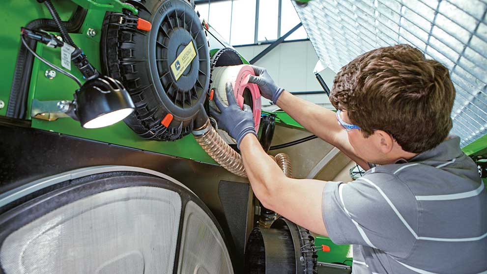 A technician changes an oil filter in a machine