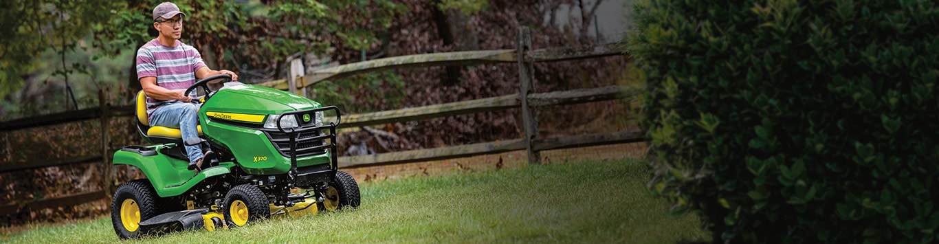 Man driving a x370 mower in his yard