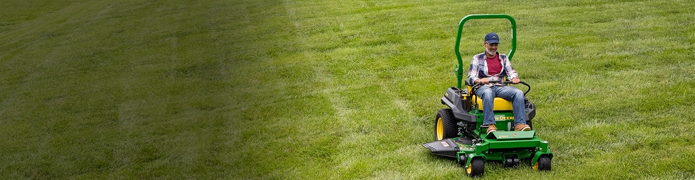 Man driving a z720e mower in a grass field