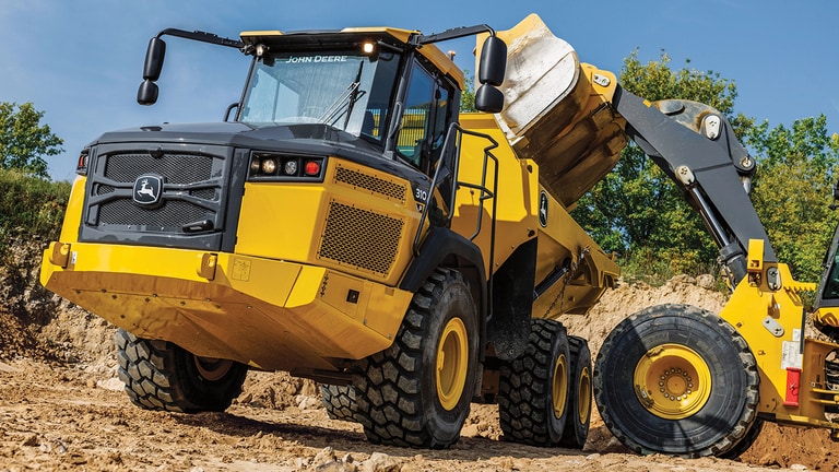 A wheeled loader dumping dirt into a 310P Articulated Dump Truck.