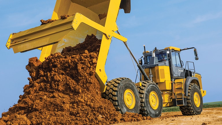 A 460P Articulated Dump Truck dumping dirt onto a worksite.