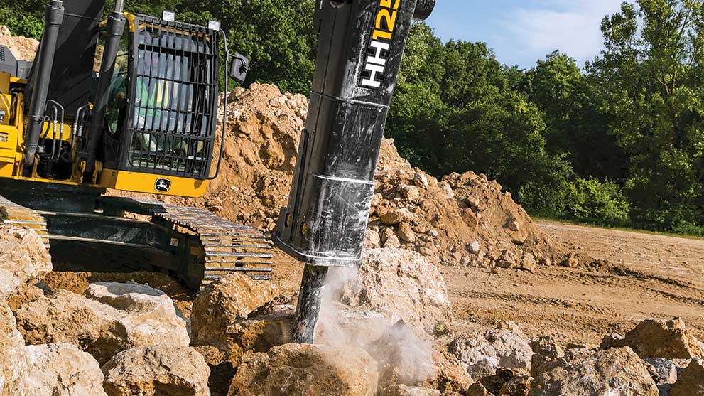 HH125 breaker hammers into a pile of limestone