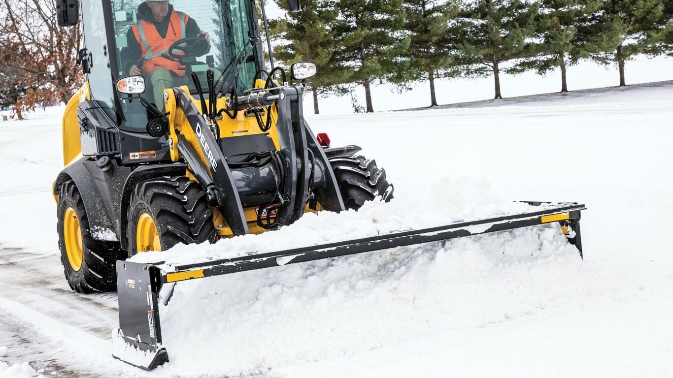 224L Wheel Loader with an SP10C Snow Pusher Attachment pushing snow in a parking lot