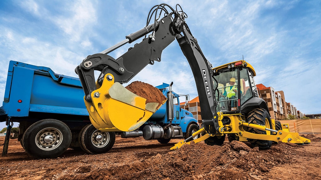 John Deere 410 P-Tier backhoe picks up a scoop of dirt