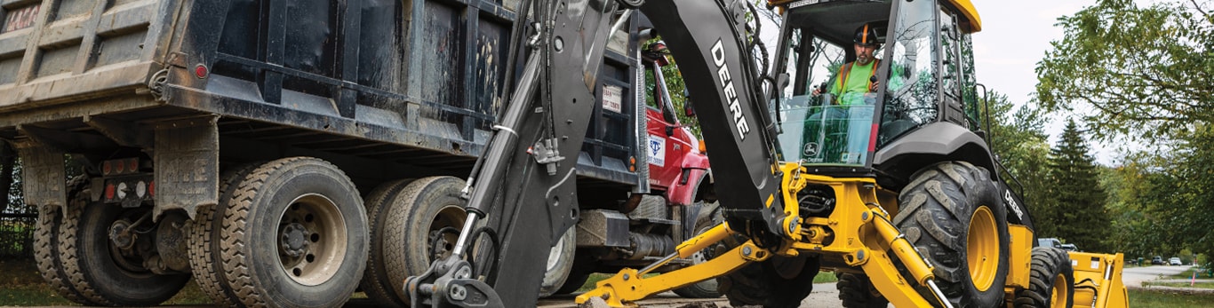 John Deere backhoe loader working on construction site.