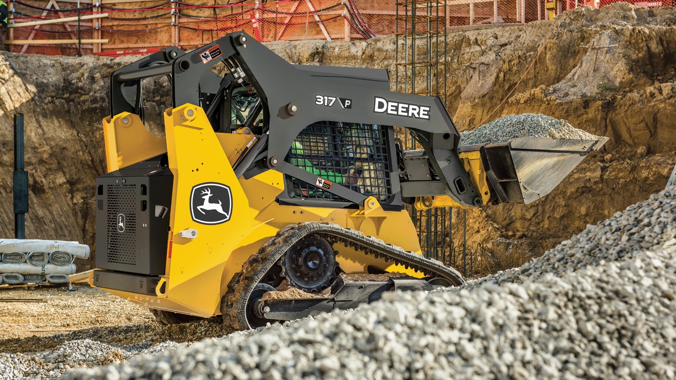317 P-Tier compact track loader using bucket attachment to move gravel on job site.