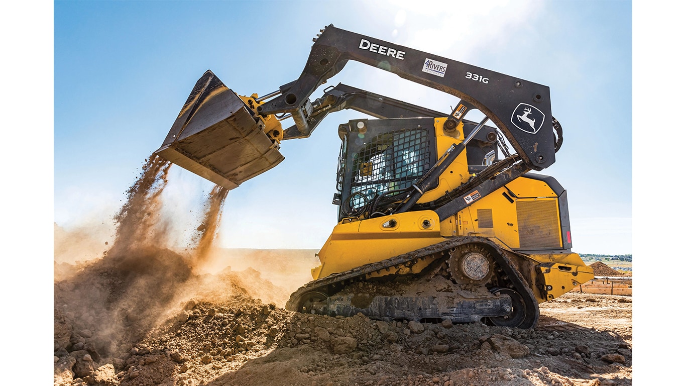 A 331G Compact Track Loader dumping dirt at a worksite.