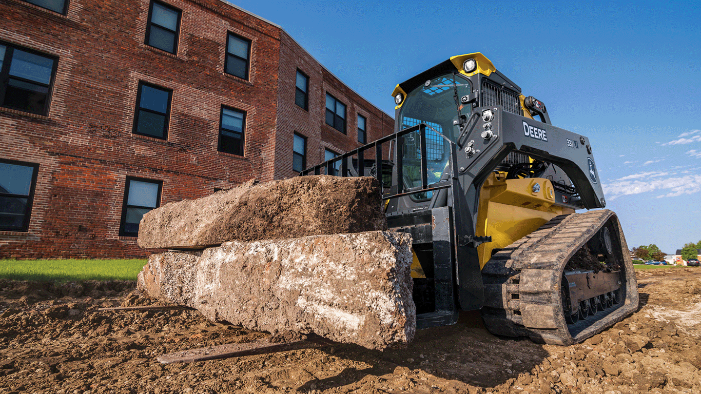 331 P-Tier compact track loader with fork attachment moving large boulders.