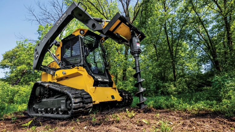331 P-Tier compact track loader using auger attachment to drill a hole in dirt.